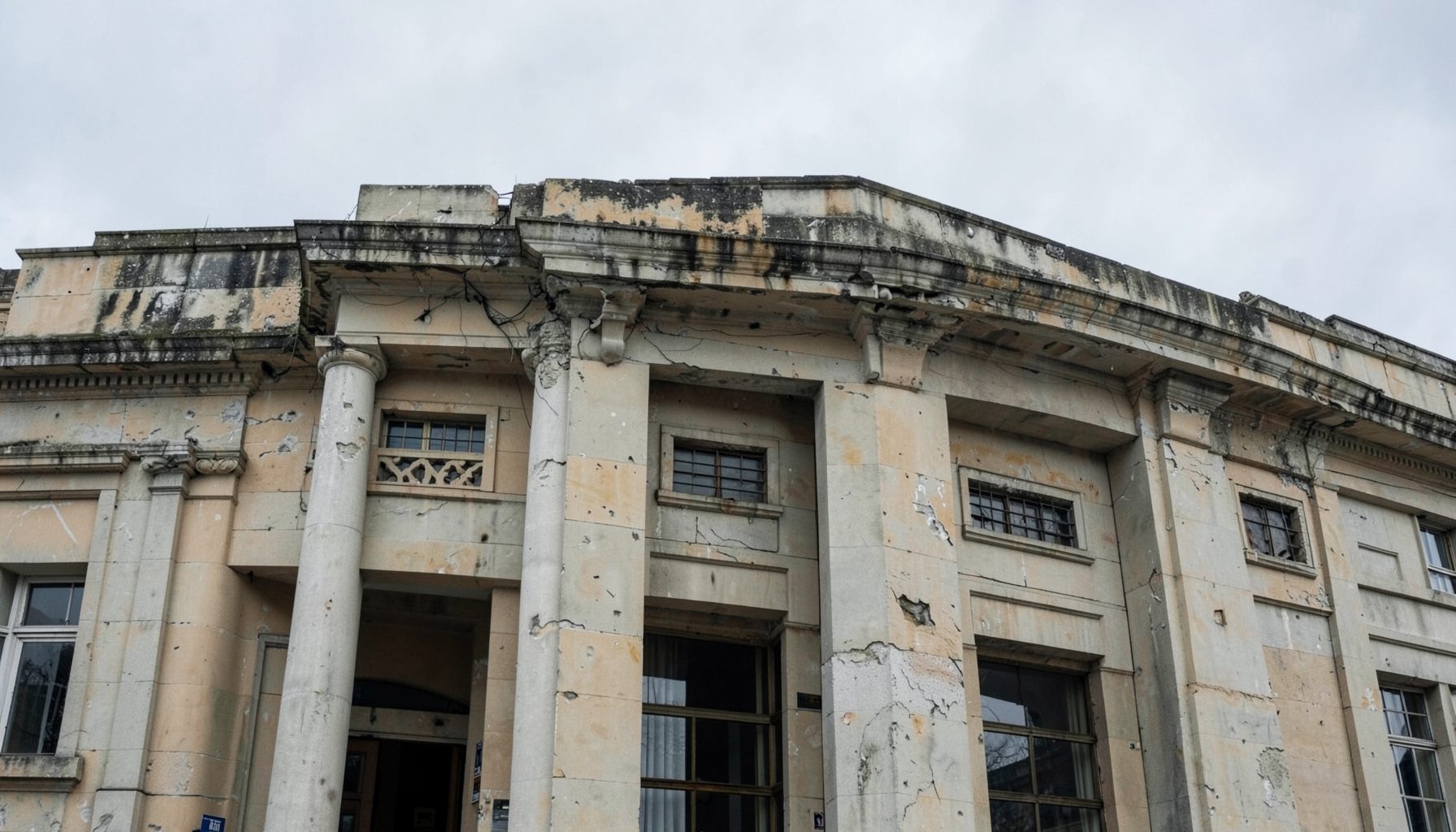 A weathered government building facade under an overcast sky, rendered in muted greys and pale ochre, suggesting institutional accountability and state scrutiny.