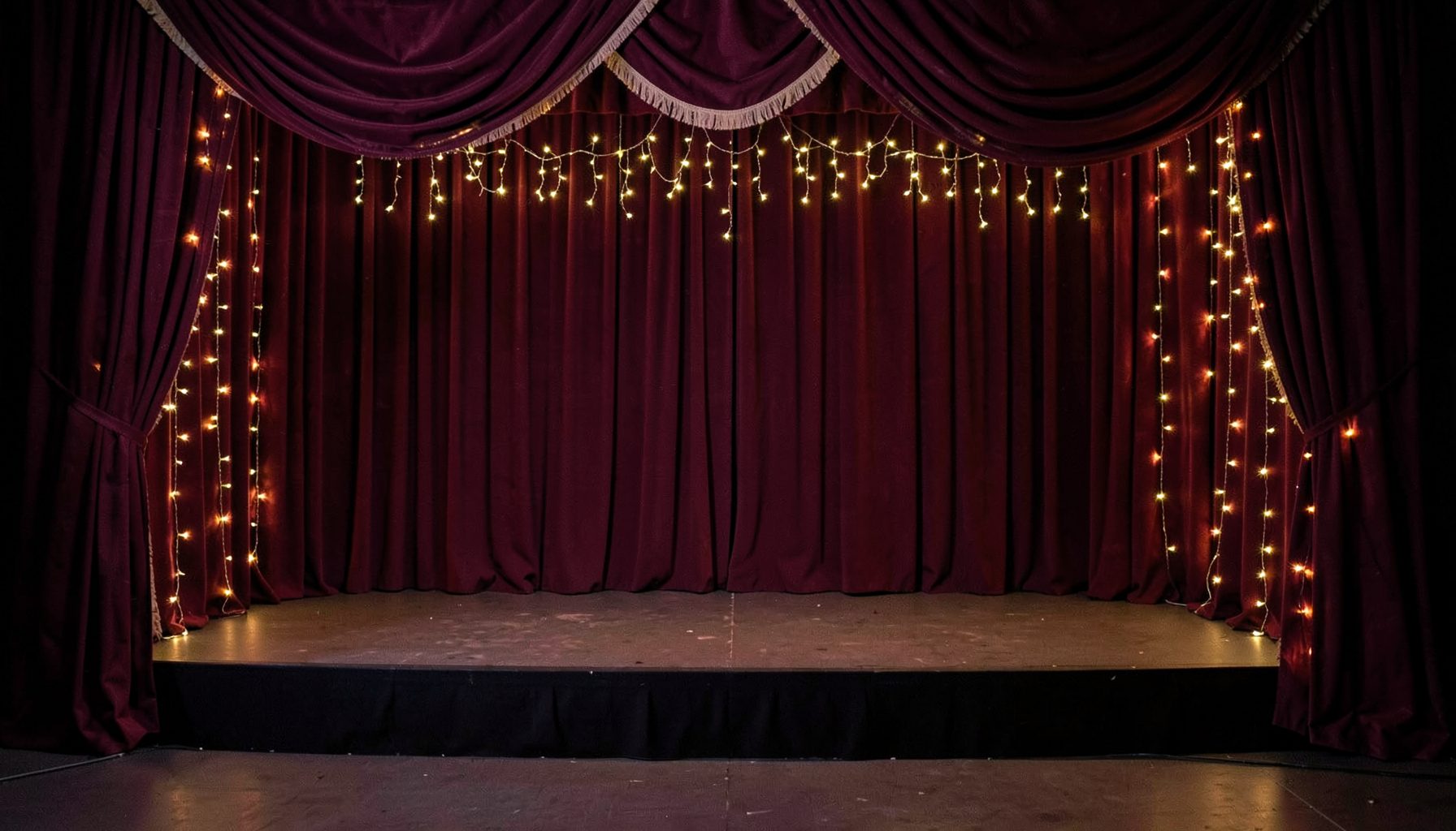 A glamorous Kannywood-style event backdrop with rich burgundy drapes and soft golden fairy lights